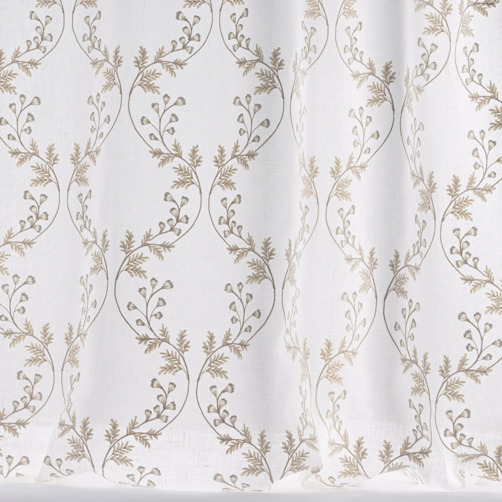 Sheer ivory fabric with scrolling vine embroidery in soft beige and taupe