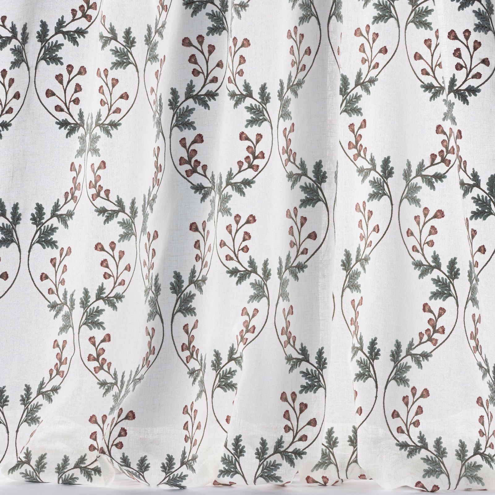 Sheer white fabric with looping vine garlands in muted pink and old blue-green