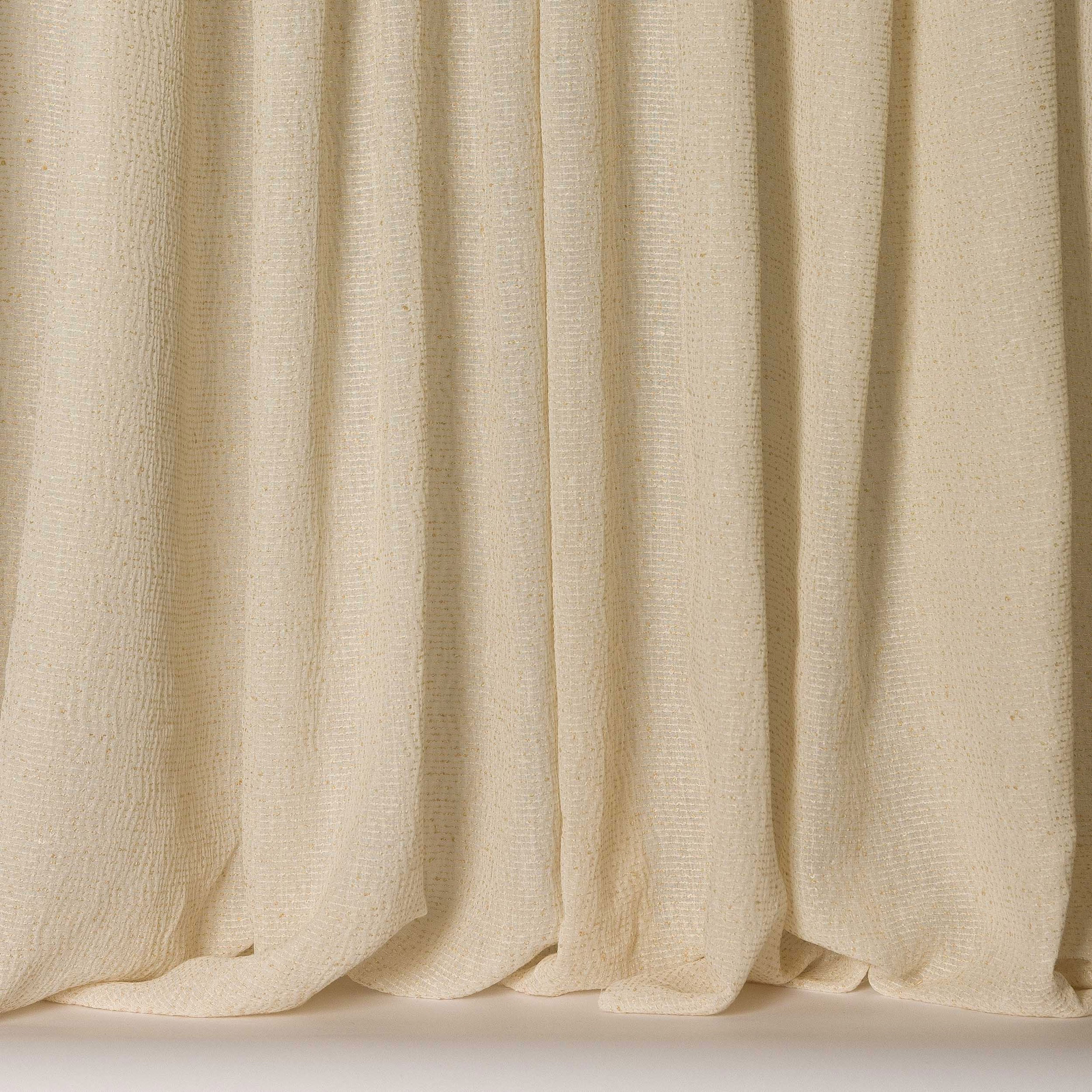 Creamy clay-toned textured fabric hanging in soft vertical folds