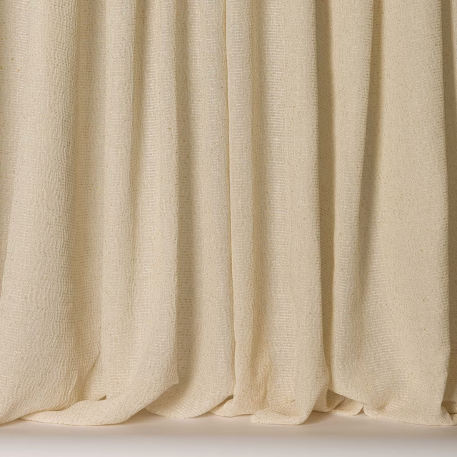 Creamy clay-toned textured fabric hanging in soft vertical folds