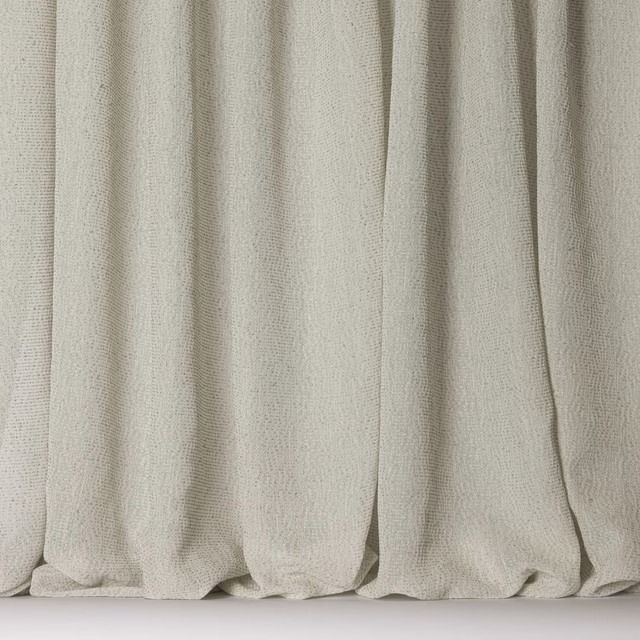 Pale cream textured fabric hanging in soft vertical folds