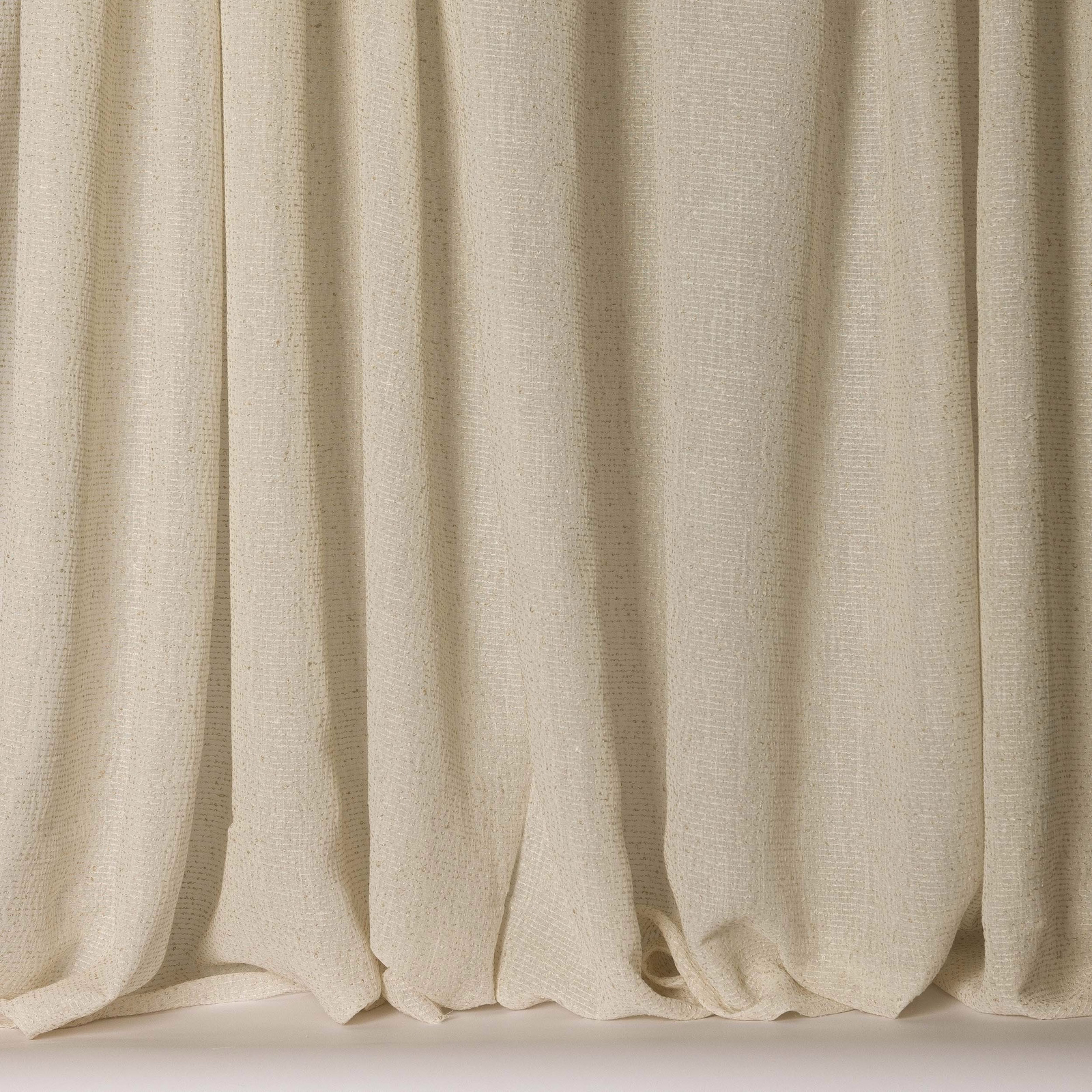 Soft ivory textured fabric hanging in gentle vertical folds, wide width sample