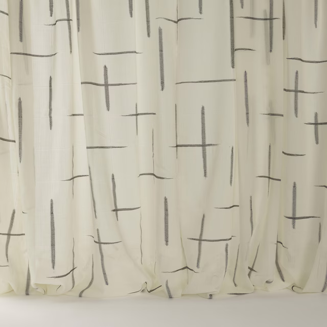 Ivory wool fabric with scattered ebony linear marks and soft hanging folds