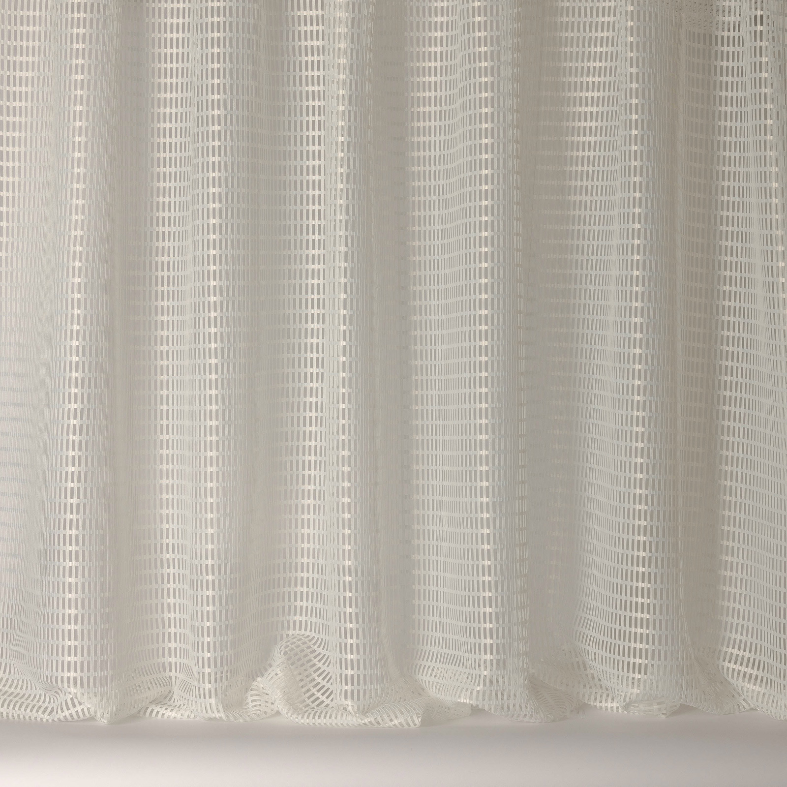 Soft warm white sheer fabric with fine woven grid stripes and relaxed folds