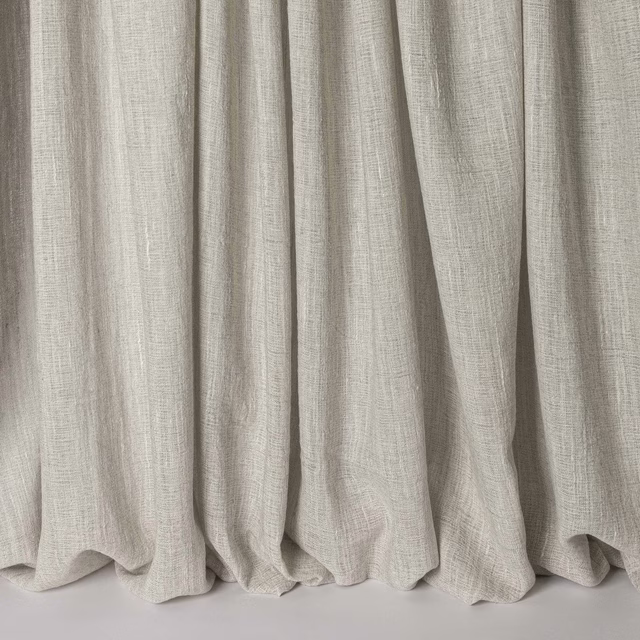 Soft warm grey linen-blend fabric hanging in gentle vertical folds
