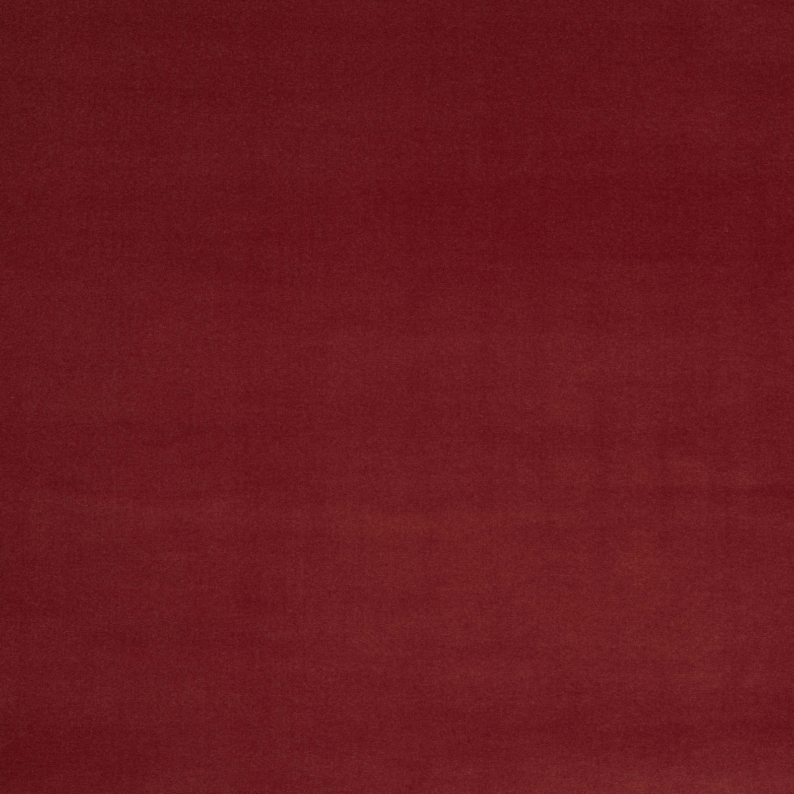 Close-up of a plain deep brick red fabric with a fine matte texture