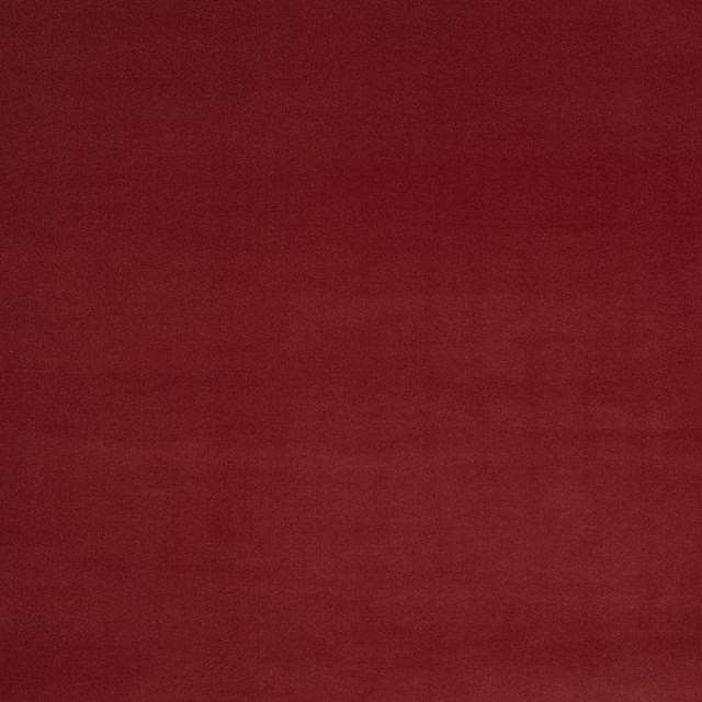Close-up of a plain deep brick red fabric with a fine matte texture