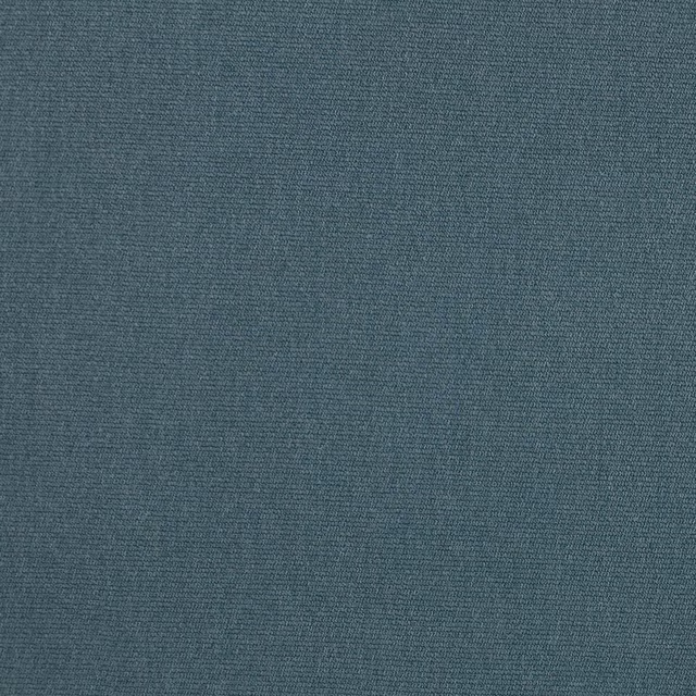 Close-up of a muted Prussian blue woven fabric with a fine, even texture