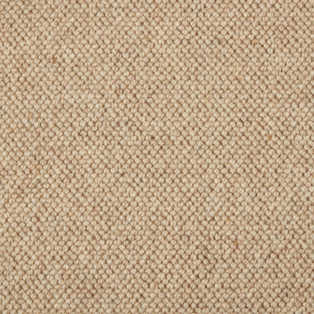 Warm oatmeal-beige wool loop carpet showing a dense, pebble-like textured surface