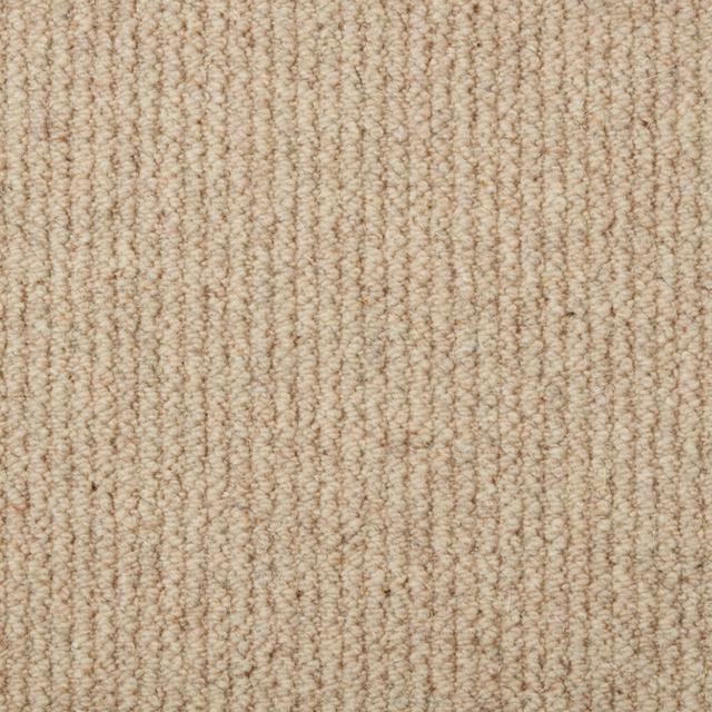 Warm oat-beige carpet showing dense, irregular vertical loop texture