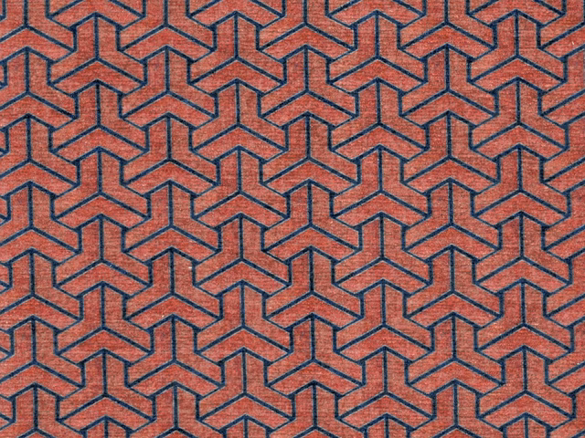 Terracotta chenille swatch with dark teal interlocking geometric lines and tactile weave