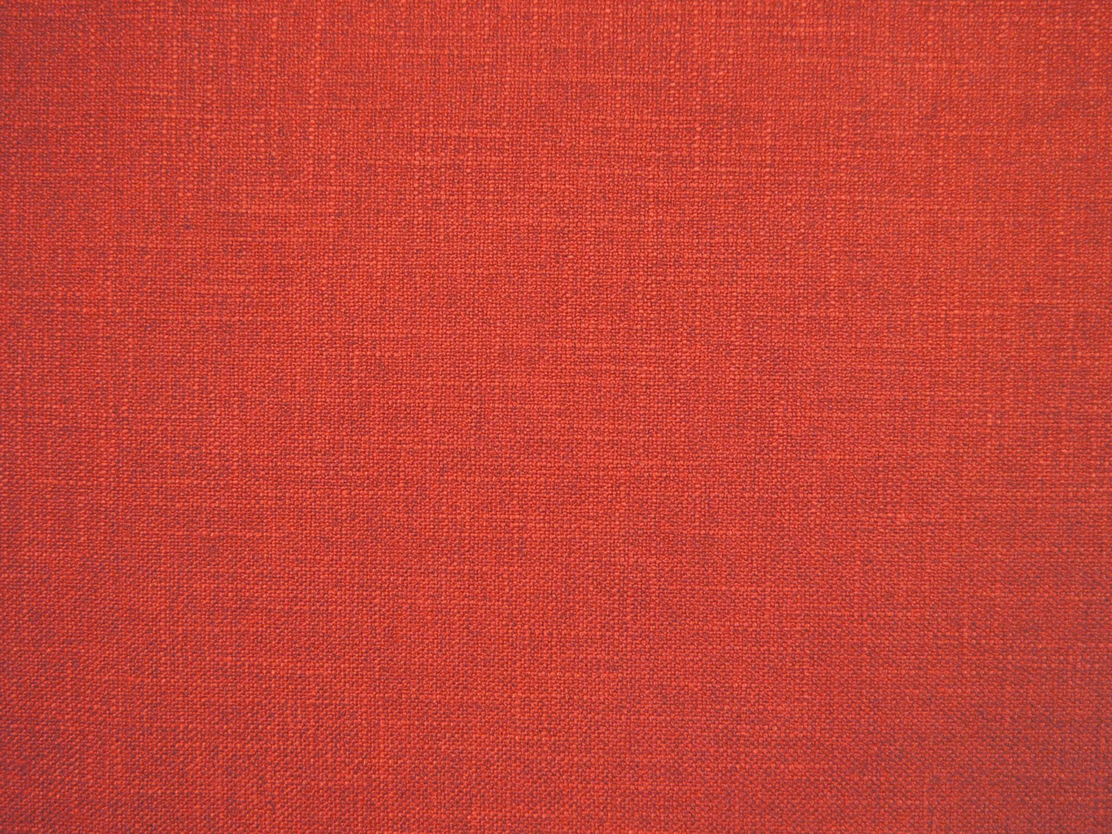 Warm coral-red faux-linen swatch showing a fine crosshatched woven texture