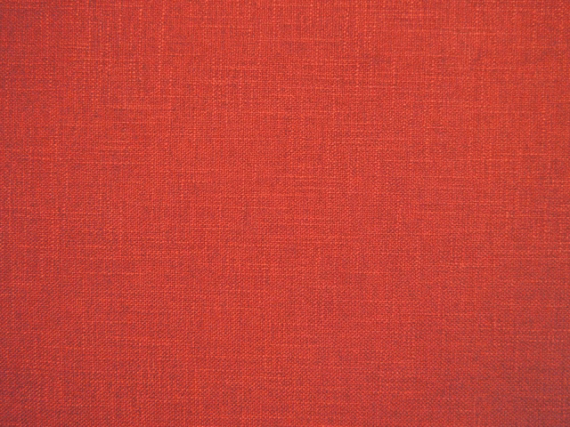 Warm coral-red faux-linen swatch showing a fine crosshatched woven texture