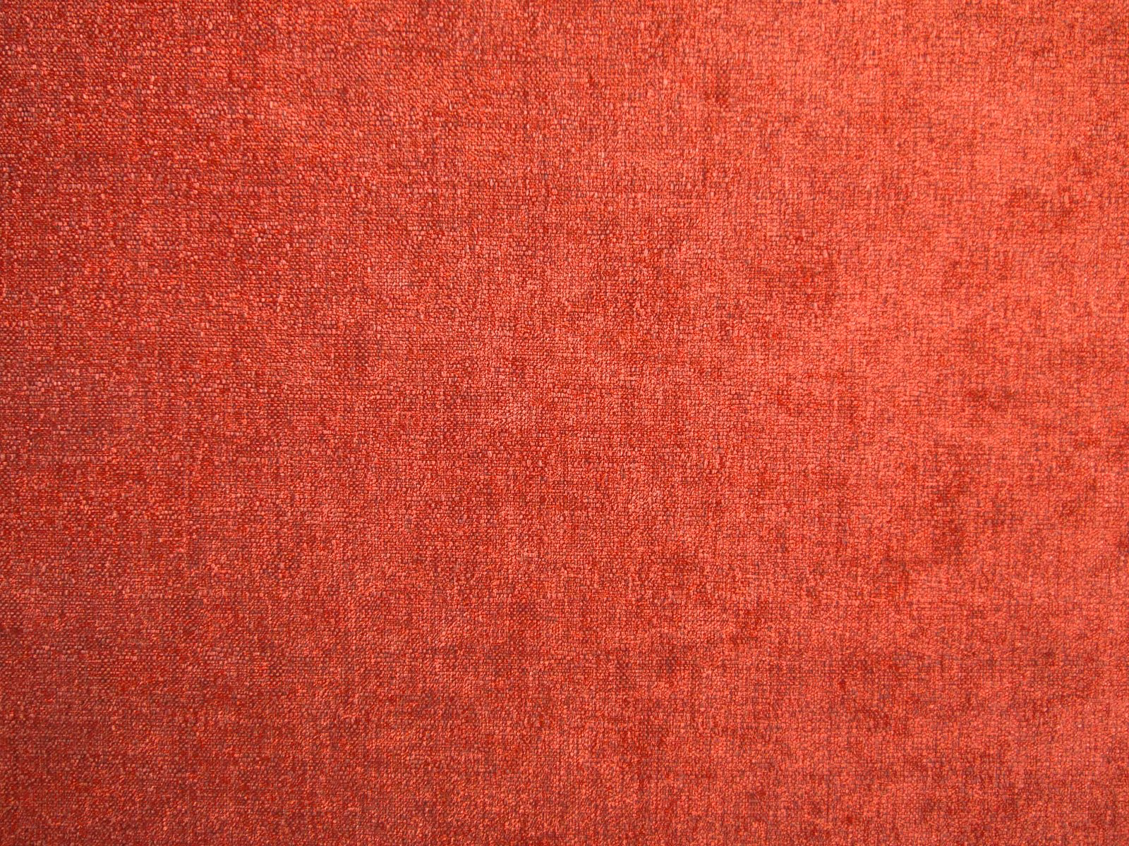 Warm coral-red chenille with softly mottled, nubby woven texture