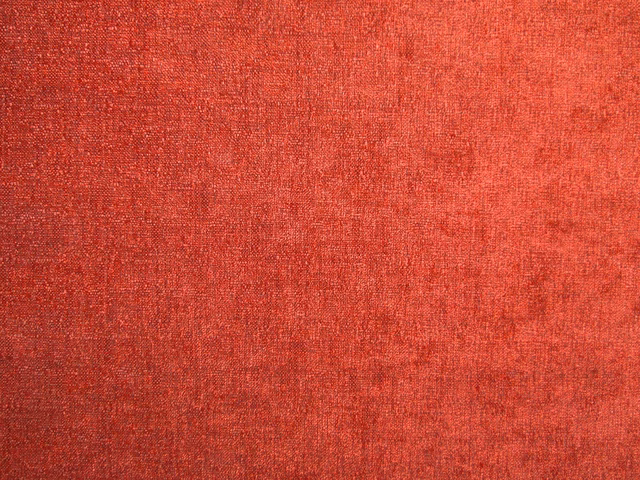 Warm coral-red chenille with softly mottled, nubby woven texture