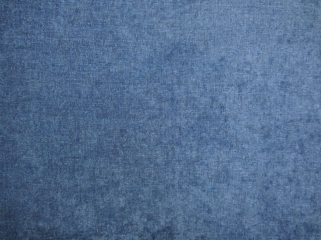 Close-up of muted denim-blue chenille with a softly mottled, brushed surface