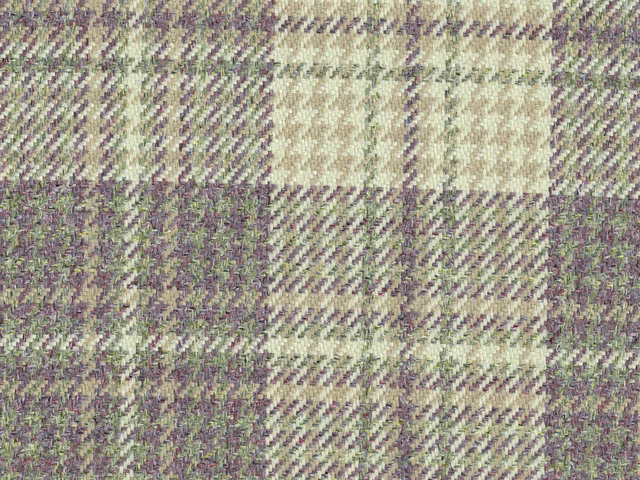 Close view of a sage, lilac and cream checked flat weave with mottled texture