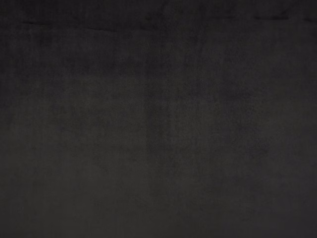 Charcoal-black plain velvet swatch showing a plush nap and subtle tonal sheen