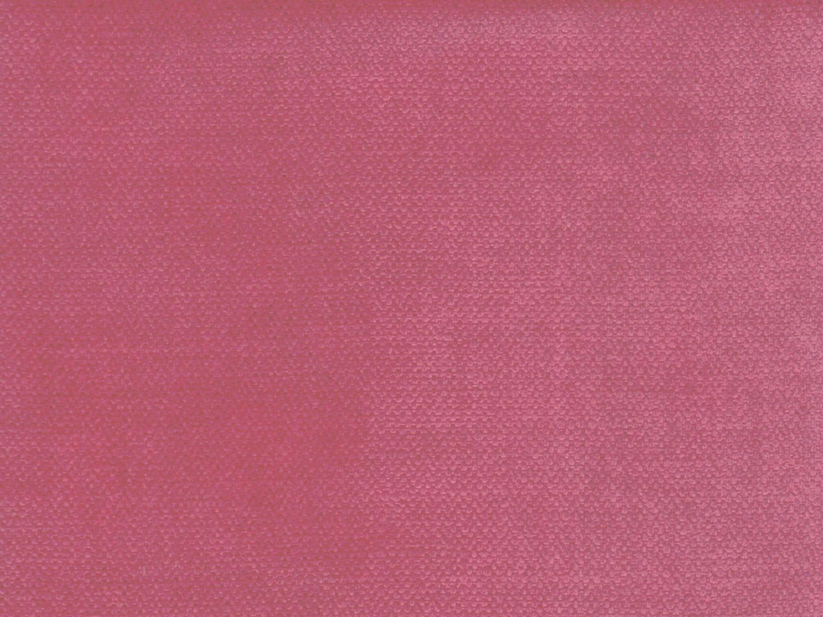 Close-up of deep raspberry pink velvet with a fine, softly mottled texture