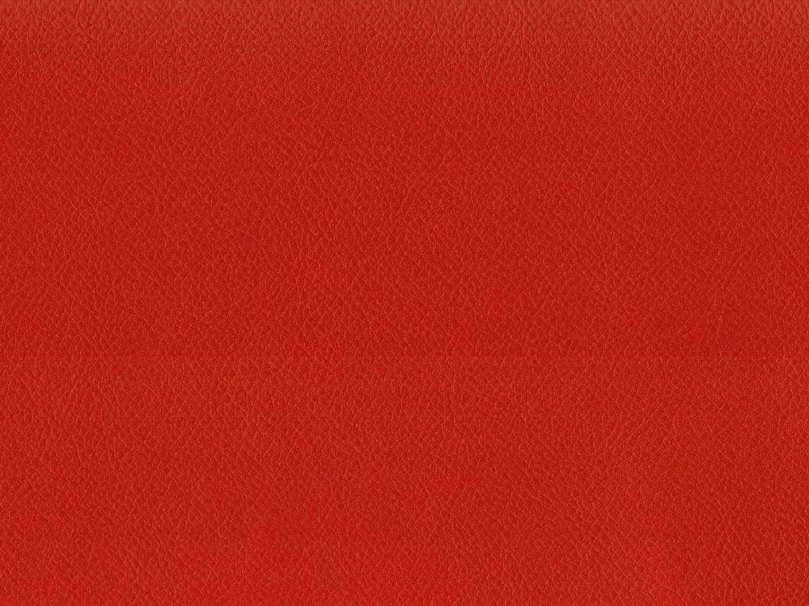 Close-up of scarlet red faux leather with a fine, pebbled grain