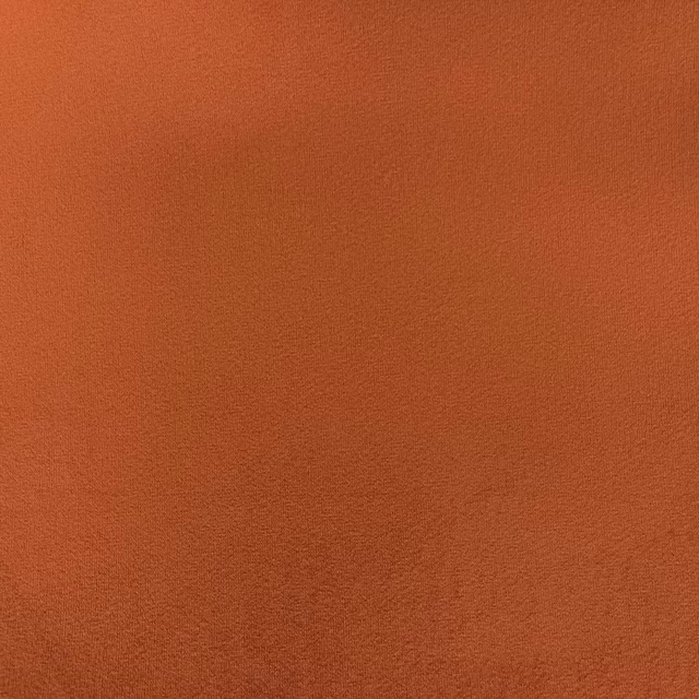 Close-up of burnt terracotta velvet with a softly brushed, shaded surface