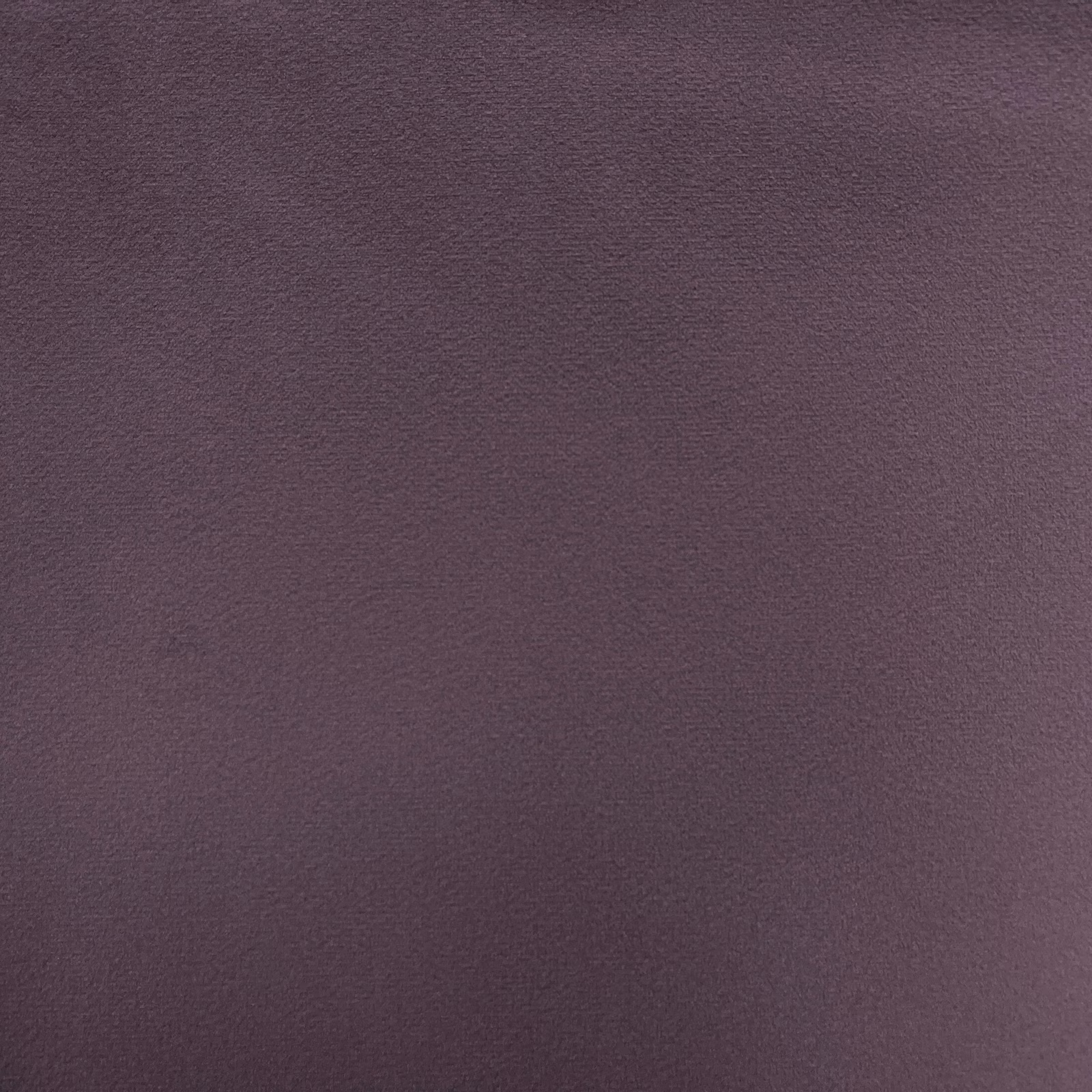 Close-up of deep muted plum-mauve velvet with softly shaded, fine nap