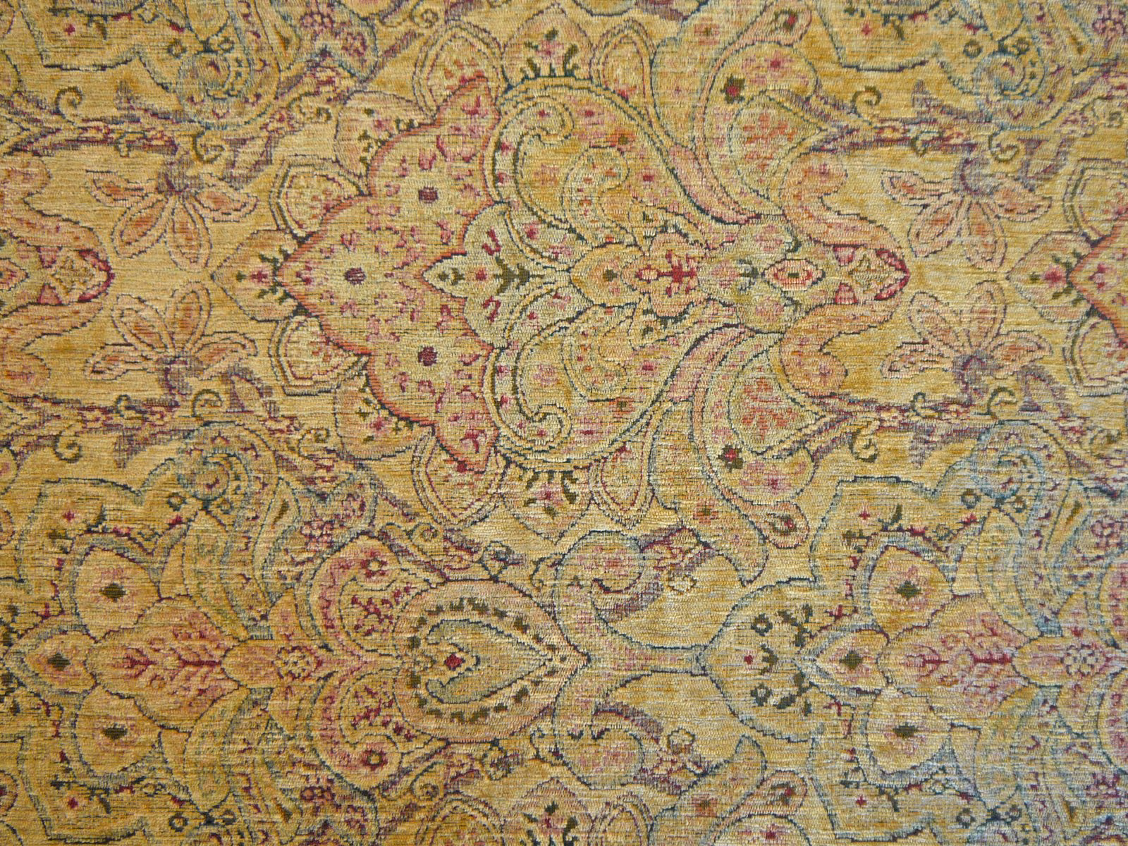 Ochre chenille with olive, mauve and blue paisley motifs in close view