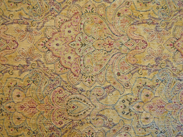 Ochre chenille with olive, mauve and blue paisley motifs in close view
