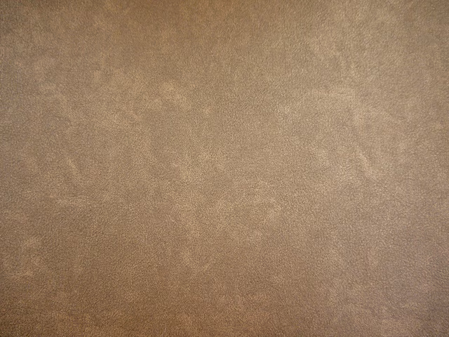 Warm mushroom-taupe faux leather with subtle cloudy mottling across the surface