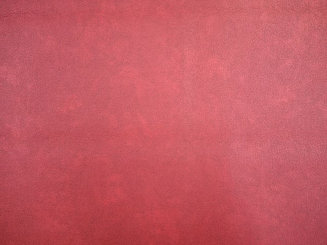 Deep raspberry-red faux leather with softly mottled, lightly grained surface