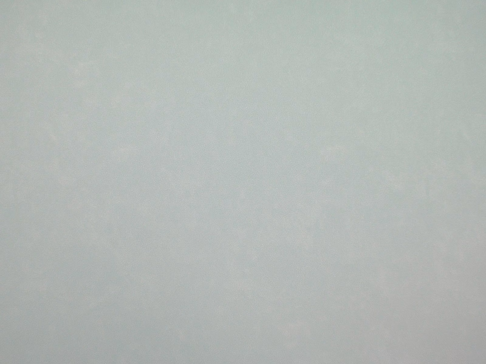 Pale sage-grey faux leather swatch with subtle cloudy mottling and soft sheen