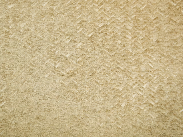 Warm beige-gold chenille with softly broken chevron markings and a tactile mottled pile