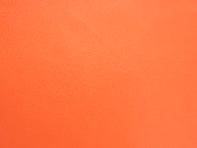 Vivid warm orange faux leather with a smooth, finely grained plain surface