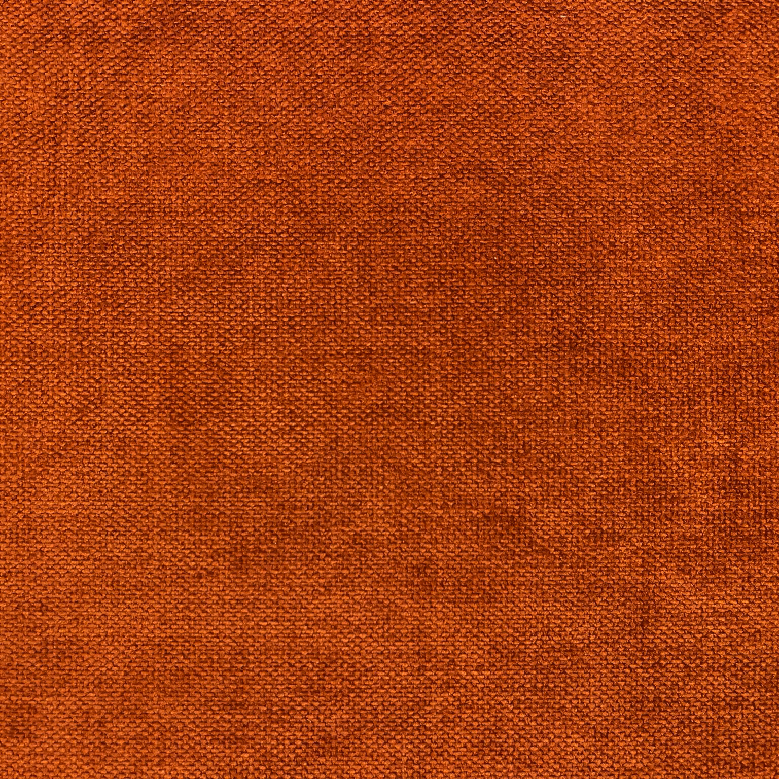 Close-up of burnt-rust orange chenille with a softly mottled woven surface