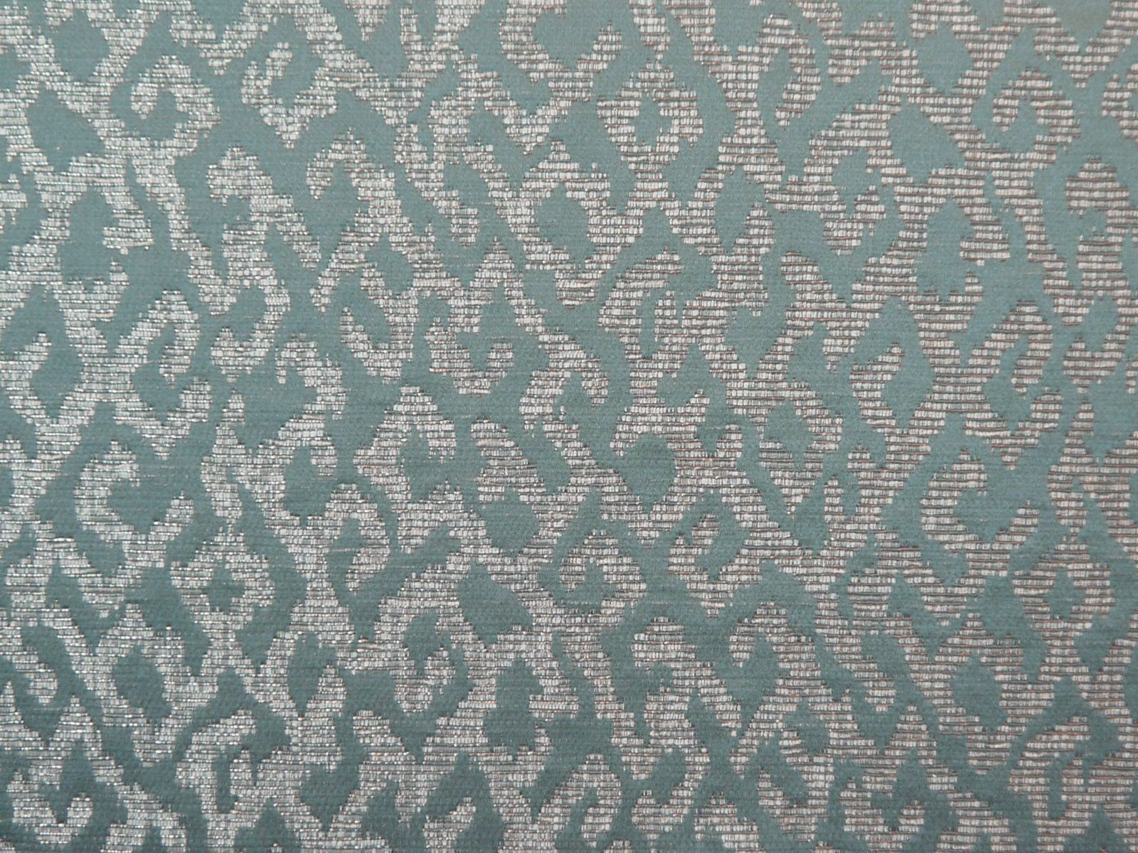 Teal chenille with pale ivory scrolling motifs and a softly nubby woven surface