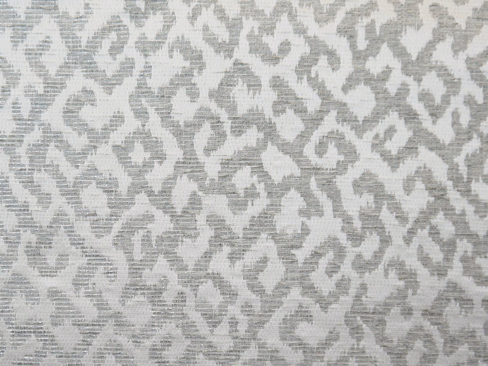 Silver-grey chenille with chalk-white organic scroll motifs and a fine ribbed texture