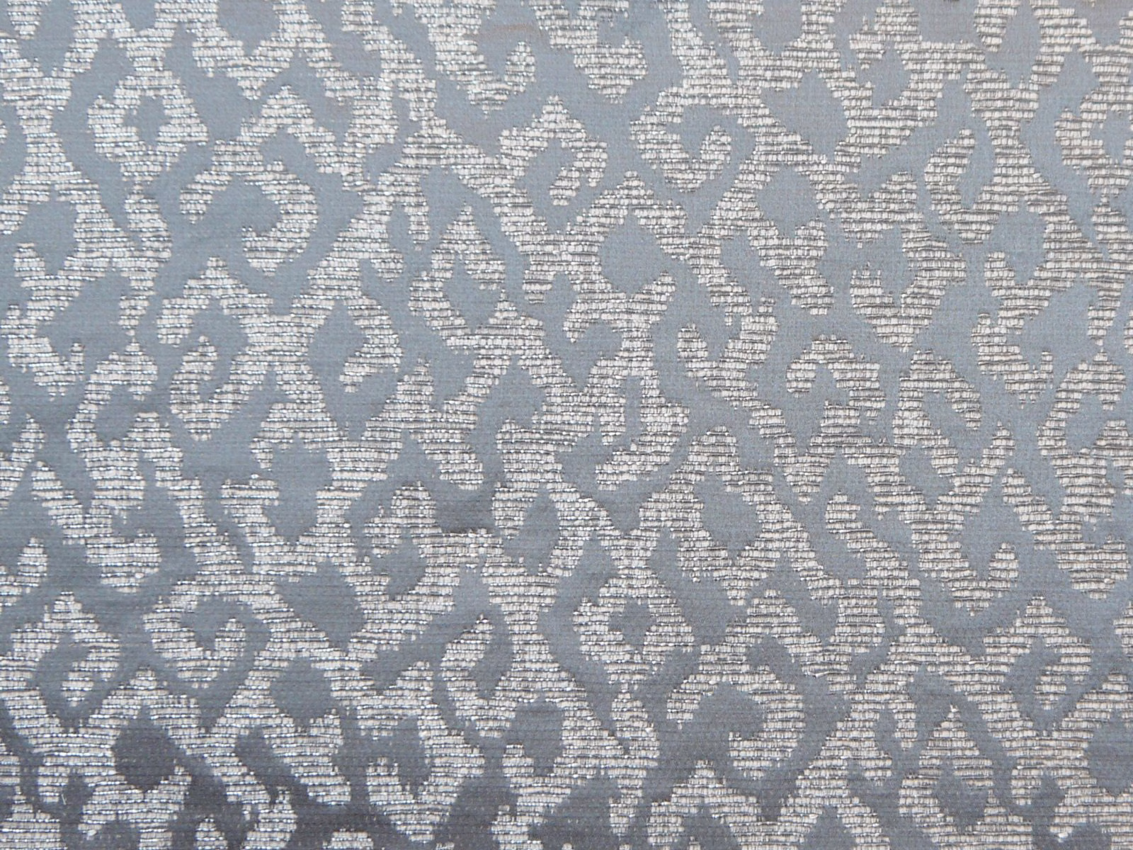 Cool blue-grey chenille with ivory scrolling motifs and a softly mottled woven texture