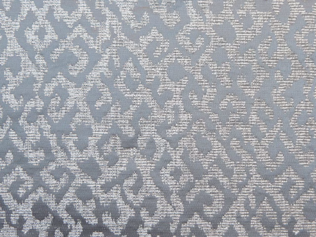 Cool blue-grey chenille with ivory scrolling motifs and a softly mottled woven texture