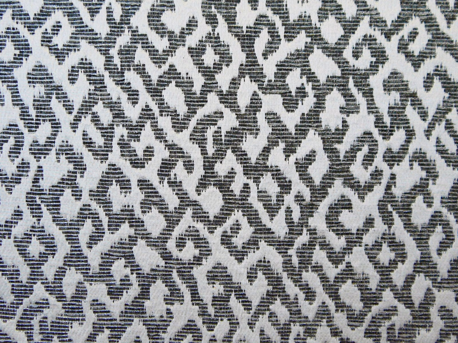 Cool charcoal and silver-grey chenille with dense curling motifs and ribbed texture