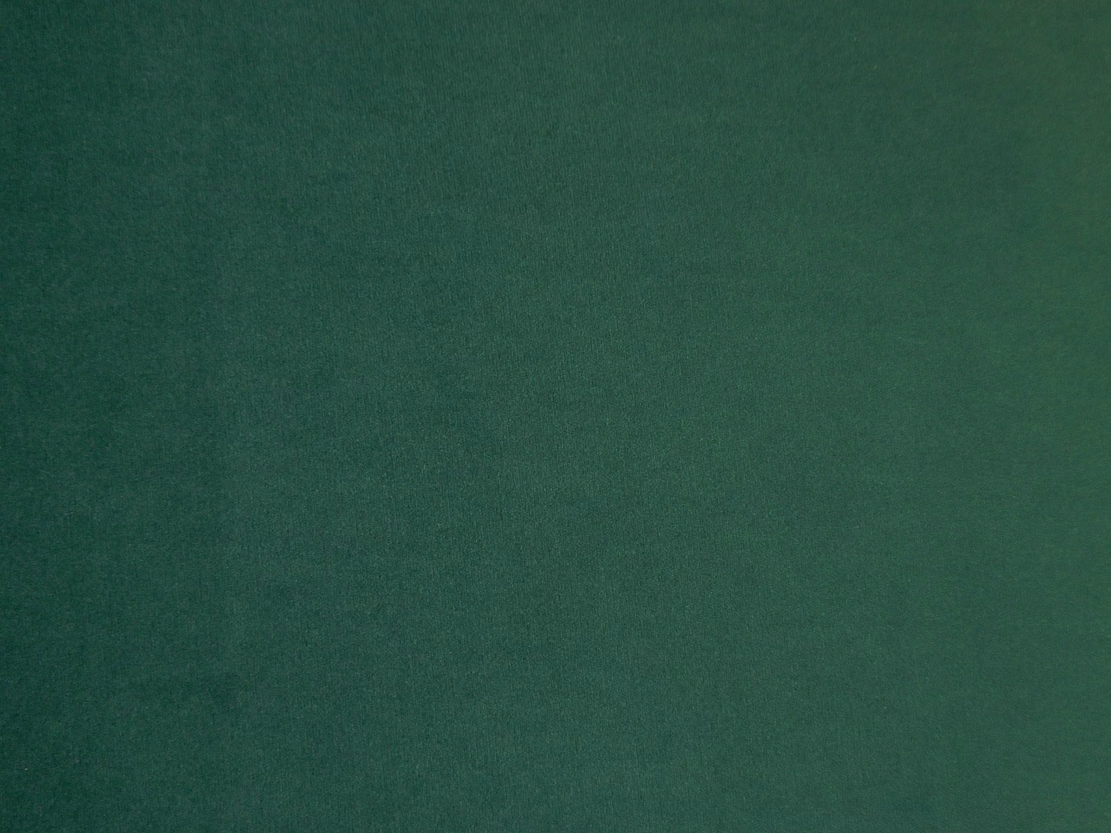 Deep forest-green velvet swatch showing soft nap and subtle tonal light variation