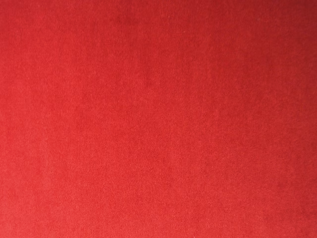 Deep crimson-red plain velvet showing soft directional nap and subtle tonal shading
