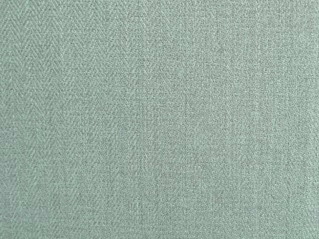 Close-up of muted sage-green chenille with a fine diagonal woven texture
