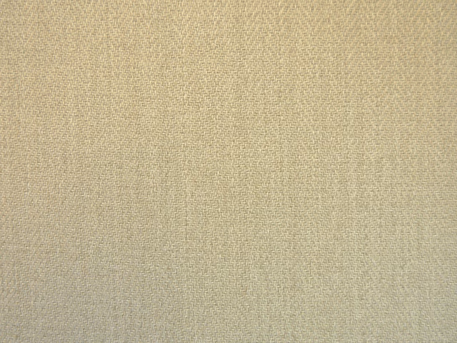 Close-up of warm oat-beige chenille with fine crosshatched woven texture