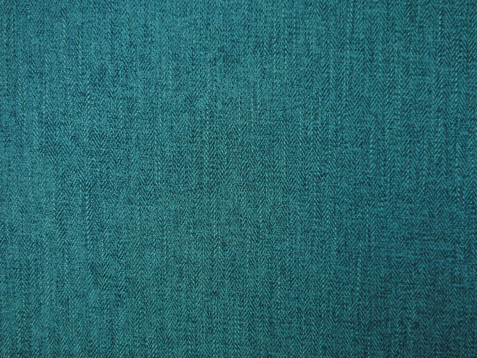 Close-up of saturated teal chenille with a fine, shadowed herringbone weave