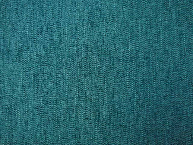 Close-up of saturated teal chenille with a fine, shadowed herringbone weave