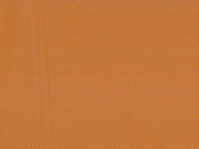 Warm burnt-orange faux leather with fine pebbled grain and subtle vertical creasing