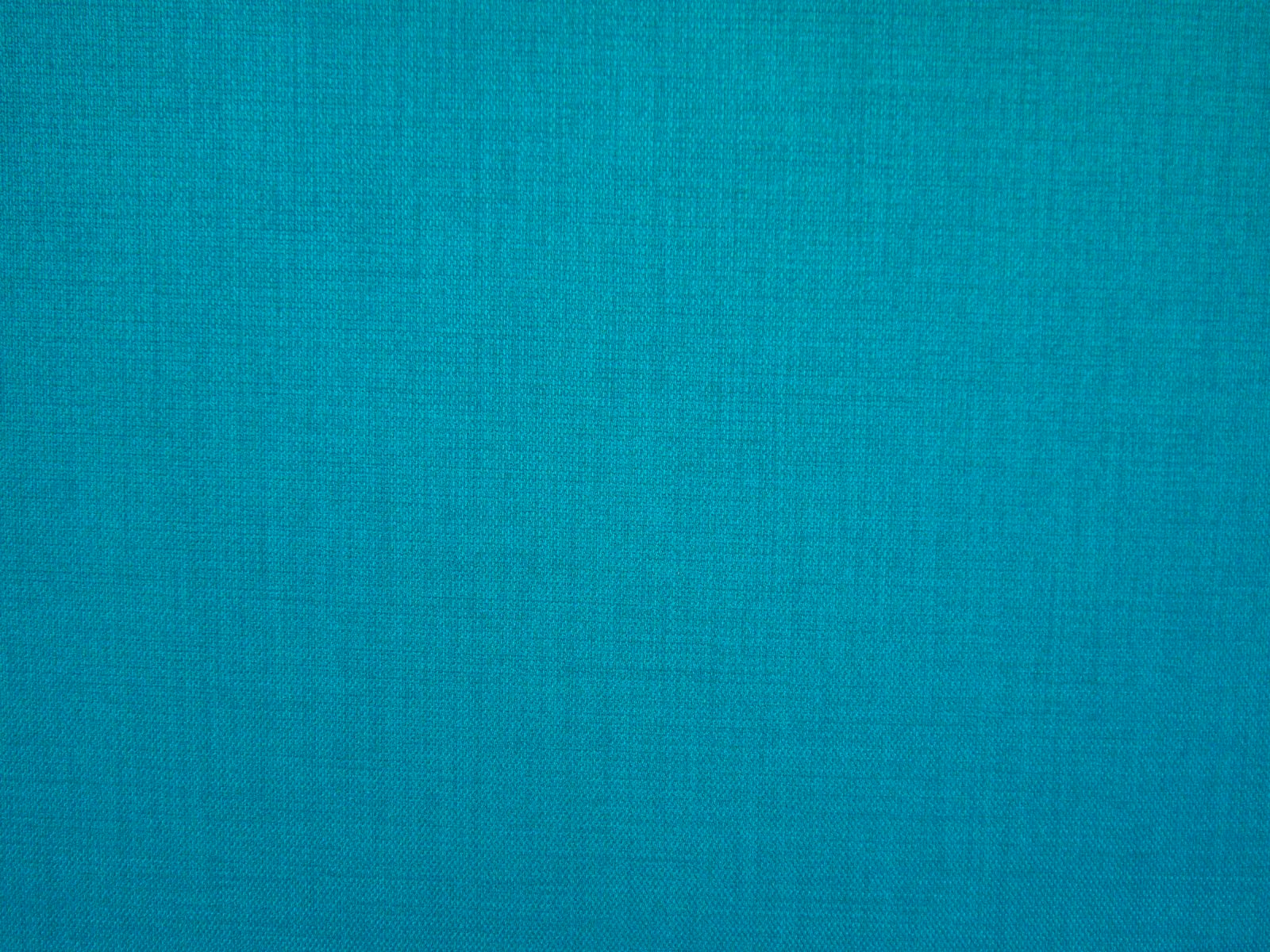 Bright turquoise teal flat-weave textile showing a fine crosshatch surface