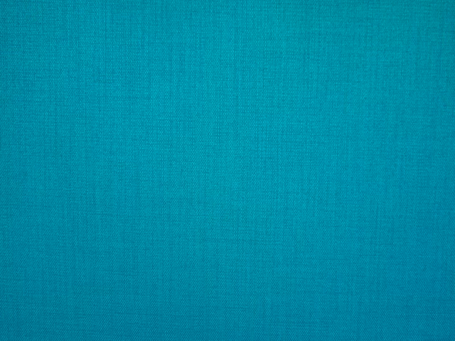 Bright turquoise teal flat-weave textile showing a fine crosshatch surface