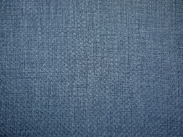 Muted slate-blue flat weave with a fine crosshatched texture and softly varied threads