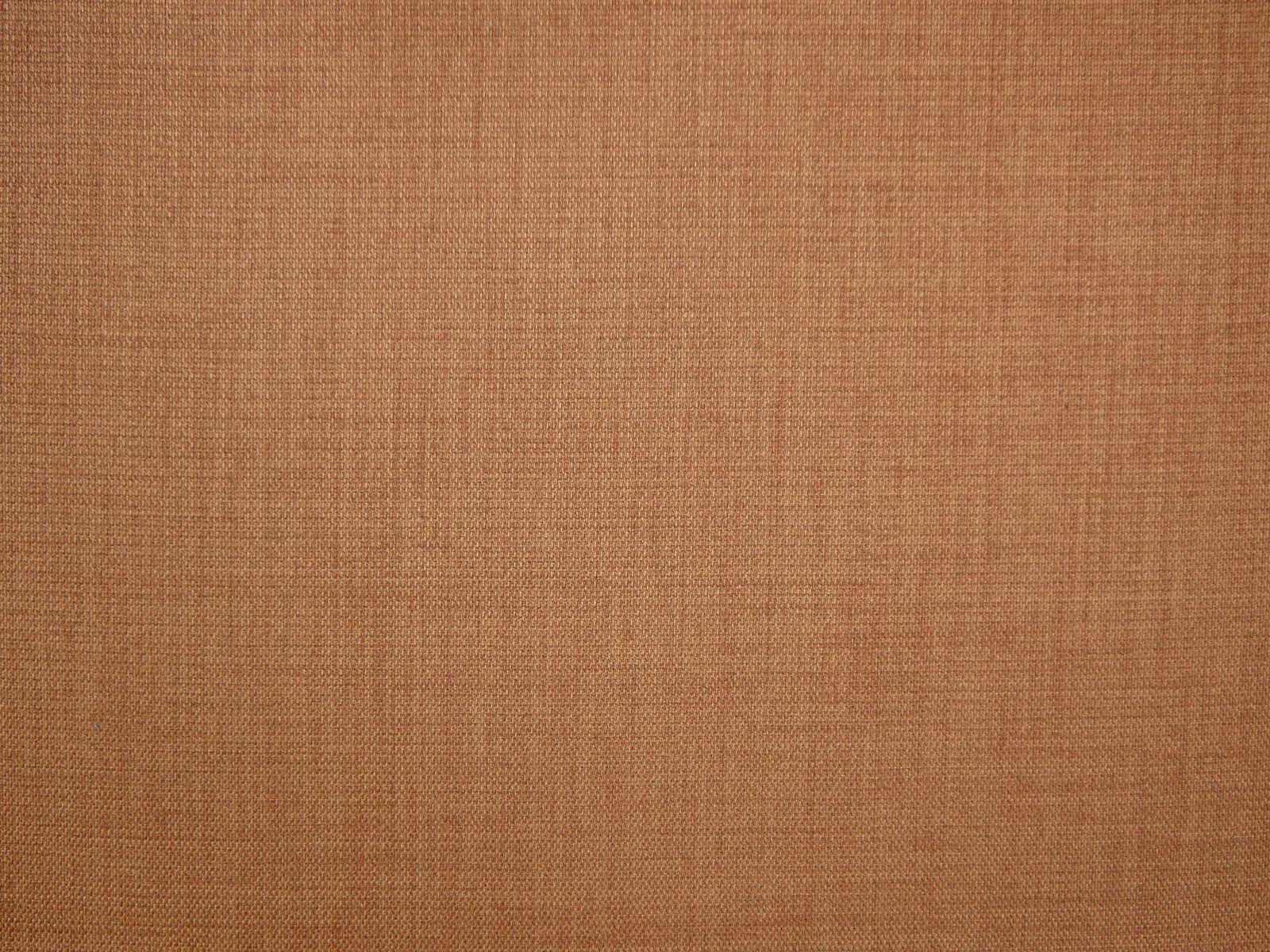 Warm terracotta flat-weave textile showing a fine, even crosshatch texture
